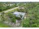 Aerial view of a charming home surrounded by lush greenery and mature trees in a serene setting at 5403 Fleming St, Port Charlotte, FL 33981