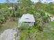 Aerial view of a home with a white exterior, surrounded by lush greenery, and a fenced in yard at 5403 Fleming St, Port Charlotte, FL 33981