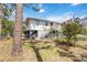 A backyard featuring a well-maintained lawn, shaded lounging area, and charming landscaping at 5403 Fleming St, Port Charlotte, FL 33981