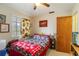 Bedroom with ceiling fan, door to hallway, window with blinds, and framed art at 5403 Fleming St, Port Charlotte, FL 33981