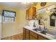 Traditional style kitchen with double bowl sink, wood cabinets, and yellow walls at 5403 Fleming St, Port Charlotte, FL 33981