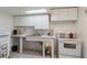 Bright kitchen featuring white cabinets, countertop, and appliances against tile flooring at 5403 Fleming St, Port Charlotte, FL 33981
