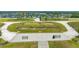 Aerial view of a meticulously landscaped community area with benches, walkways, and a serene lake backdrop at 5475 Summit Gln, Bradenton, FL 34203
