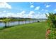 Lush backyard with a black metal fence offering serene lake views, enhanced by vibrant greenery at 5475 Summit Gln, Bradenton, FL 34203