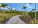 Picturesque community walking path lined with lush greenery and palm trees, inviting residents to explore nature at 5475 Summit Gln, Bradenton, FL 34203