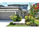 Beautiful single-Gathering home featuring a gray exterior, well-kept lawn, and colorful landscaping at 5475 Summit Gln, Bradenton, FL 34203