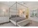 The spacious primary bedroom features a four-poster bed, stylish furnishings, and a tranquil ambiance at 5475 Summit Gln, Bradenton, FL 34203