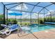 This serene pool area is enclosed in a screened-in lanai, with comfortable lounge chairs and a beautiful lake view at 5475 Summit Gln, Bradenton, FL 34203