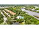 An aerial view of the condo complex with a swimming pool, river, and lush greenery at 5646 Simonton St, Bradenton, FL 34203