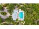 Overhead view of a community pool with ample seating, a hot tub, and shade provided by mature trees at 5646 Simonton St, Bradenton, FL 34203
