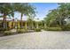 View of the clubhouse exterior with lush landscaping, a brick driveway, and a yellow facade at 5646 Simonton St, Bradenton, FL 34203