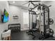 Well-equipped home gym featuring a full cage, weight rack, television, and ample workout space at 5646 Simonton St, Bradenton, FL 34203