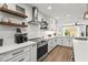 Modern kitchen with stainless steel appliances, floating shelves, and eat-in nook at 5646 Simonton St, Bradenton, FL 34203