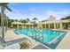 A full shot of the community pool with lounge chairs, a covered gazebo, and a bright yellow clubhouse at 5646 Simonton St, Bradenton, FL 34203