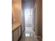 Hallway view of the bathroom with tiled floors, leading to a well-lit bathtub and shower at 5711 Bentgrass Dr # 19-203, Sarasota, FL 34235