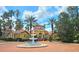 Beautiful clubhouse featuring a fountain, red tile roof, and surrounded by palm trees at 5711 Bentgrass Dr # 19-203, Sarasota, FL 34235