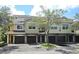Charming townhome featuring a red tile roof, private garages, and beautiful landscaping at 5711 Bentgrass Dr # 19-203, Sarasota, FL 34235