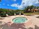 Inviting hot tub with brick surround, lounge chairs, and lush landscaping nearby at 5711 Bentgrass Dr # 19-203, Sarasota, FL 34235