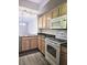Efficient kitchen featuring granite counters, white appliances, and wooden cabinets at 5711 Bentgrass Dr # 19-203, Sarasota, FL 34235