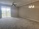 Spacious carpeted living room with sliding doors and views of nature and lots of natural light at 5711 Bentgrass Dr # 19-203, Sarasota, FL 34235