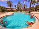 Resort-style pool surrounded by palm trees with ample lounge seating for residents at 5711 Bentgrass Dr # 19-203, Sarasota, FL 34235