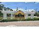 Entrance to the Las Palmas Luxury Condominiums with decorative white pergolas and lush landscaping at 5711 Bentgrass Dr # 19-203, Sarasota, FL 34235