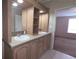 Bathroom featuring a vanity, mirrors, lighting, and an open doorway to a bedroom at 6238 Angus Valley Dr, Wesley Chapel, FL 33544