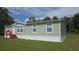Exterior view of house with light green siding, red stairs, and white trim at 6238 Angus Valley Dr, Wesley Chapel, FL 33544
