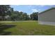 Side yard view of a house surrounded by green grass and foliage at 6238 Angus Valley Dr, Wesley Chapel, FL 33544