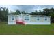 Well-maintained single-story home with a red stair landing and a lush green lawn at 6238 Angus Valley Dr, Wesley Chapel, FL 33544