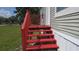 Red painted wood stairs lead to the front door of this home at 6238 Angus Valley Dr, Wesley Chapel, FL 33544