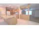 Open-concept kitchen showcases an island, wood cabinetry, and appliances seamlessly connected to the living area at 6238 Angus Valley Dr, Wesley Chapel, FL 33544