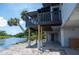 Charming home exterior featuring a waterfront view, an elevated deck, and sturdy support pillars at 6406 Lincoln Rd, Bradenton, FL 34203