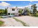 Exterior view of white two-story waterfront home with parking at 6406 Lincoln Rd, Bradenton, FL 34203