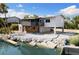 Waterfront home featuring a balcony, screened porch, and lush landscaping at 6406 Lincoln Rd, Bradenton, FL 34203