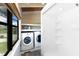 Well-lit laundry area featuring a washing machine, dryer, shelving and a shower at 6406 Lincoln Rd, Bradenton, FL 34203