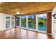 Living room featuring hardwood floors, a wood ceiling, and expansive waterfront views through large windows at 6406 Lincoln Rd, Bradenton, FL 34203