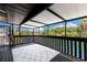 Covered porch featuring black wood rails overlooking scenic waterfront views and stylish outdoor rug at 6406 Lincoln Rd, Bradenton, FL 34203