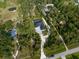 Aerial view of a home nestled among trees and a long driveway on a large lot at 6713 Taneytown St, North Port, FL 34291