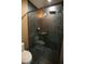 Contemporary bathroom with a glass-enclosed shower featuring black marble tiling and a hexagon-tiled floor at 6713 Taneytown St, North Port, FL 34291
