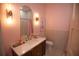 Charming pink bathroom with modern vanity, gold fixtures, and stylish chevron accent wall at 6713 Taneytown St, North Port, FL 34291