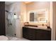 Stylish bathroom featuring a well-lit vanity, and modern glass shower with pebble floor at 6713 Taneytown St, North Port, FL 34291