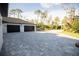 Long driveway leading to an attached three-car garage with mature landscaping at 6713 Taneytown St, North Port, FL 34291