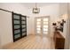 Bright foyer with modern chandelier, barn door, and wood-look tile flooring at 6713 Taneytown St, North Port, FL 34291