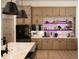 Stylish kitchen with wood cabinets, quartz countertops, tile backsplash, and open shelving with bar and beverage display at 6713 Taneytown St, North Port, FL 34291