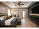 Modern main bedroom with fireplace, TV, wood floors, ceiling fan, and walkout at 6713 Taneytown St, North Port, FL 34291