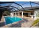 Screened pool featuring a covered patio with an outdoor kitchen and dining space at 6713 Taneytown St, North Port, FL 34291