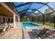 Spacious outdoor screened-in pool area complete with lounge chairs and lush greenery at 6713 Taneytown St, North Port, FL 34291