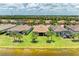 Aerial view shows the home with the lake in the backyard and tropical landscaping at 6756 Chester Trl, Lakewood Ranch, FL 34202