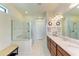Bright bathroom featuring double sinks, granite counters, glass shower and neutral tile at 6756 Chester Trl, Lakewood Ranch, FL 34202